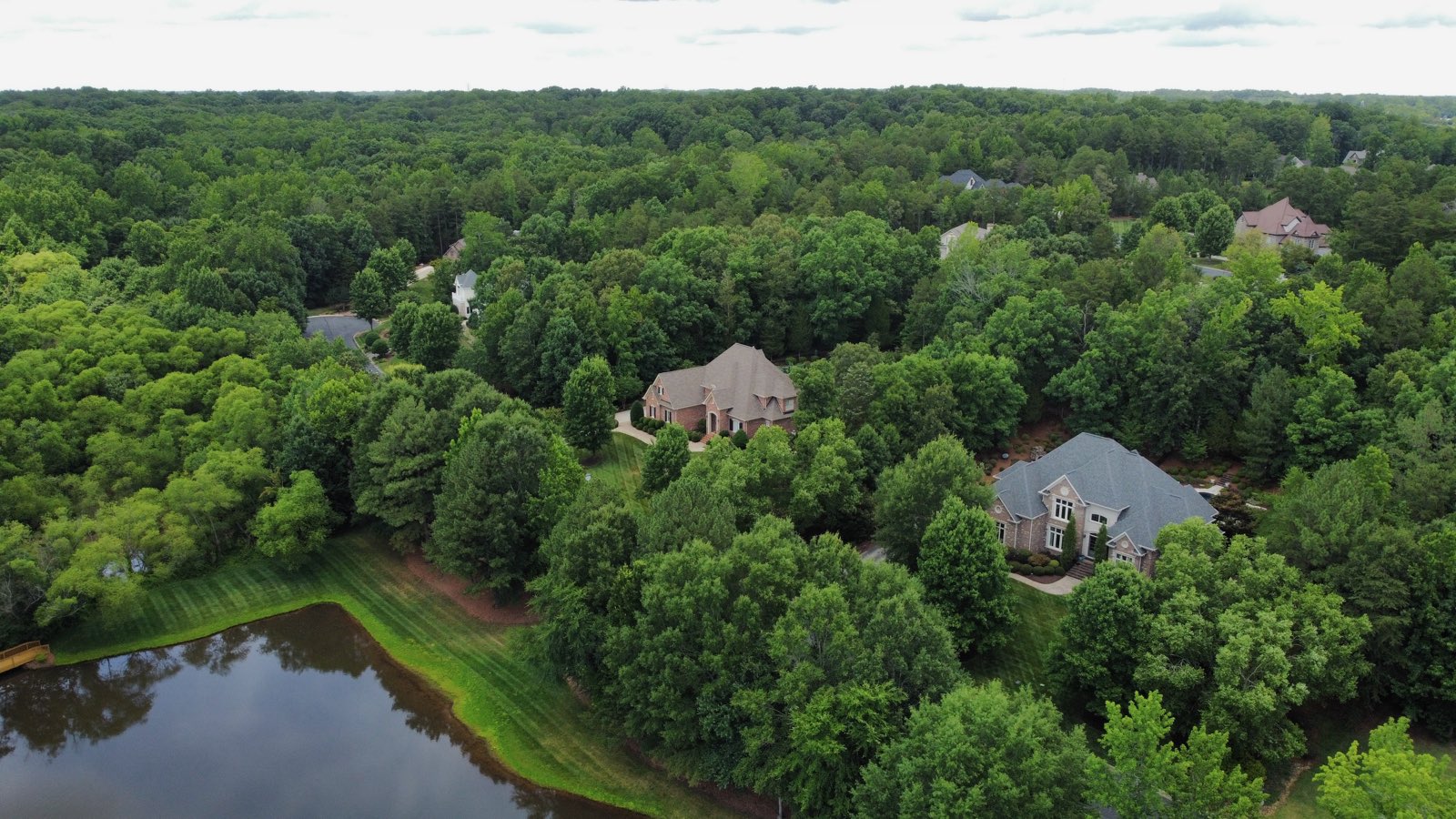 Pine Creek homes nestled among the woods near the pond