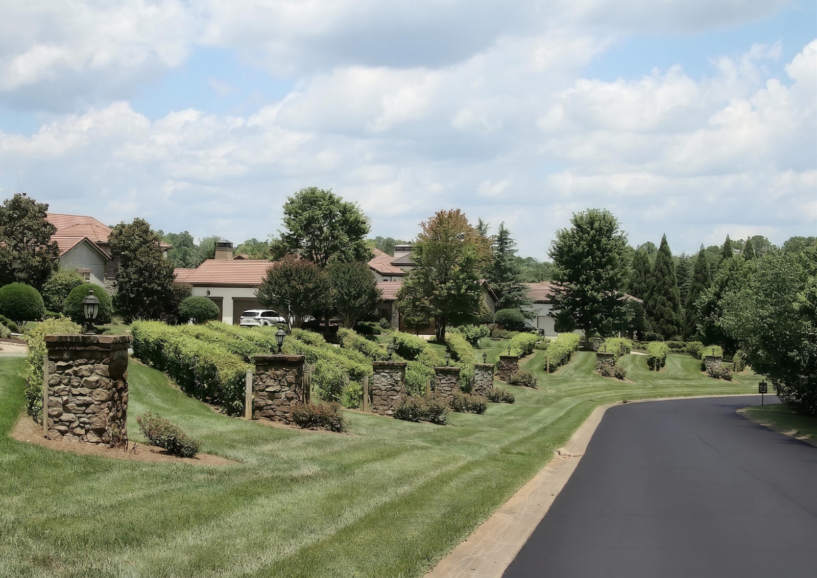 Stone-columned vineyard terraces along a tree-lined street
