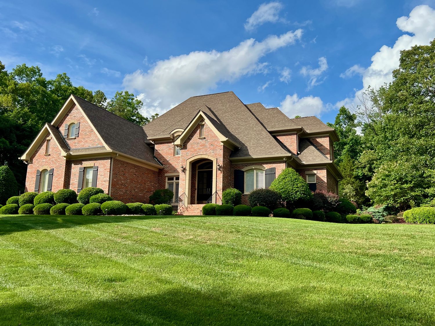 Stately brick custom home on a manicured lawn