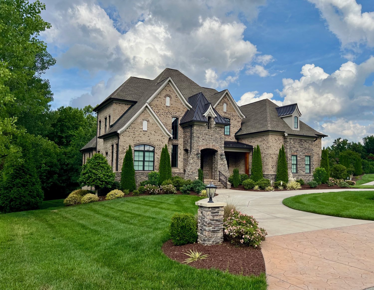 Stone custom home with circular drive