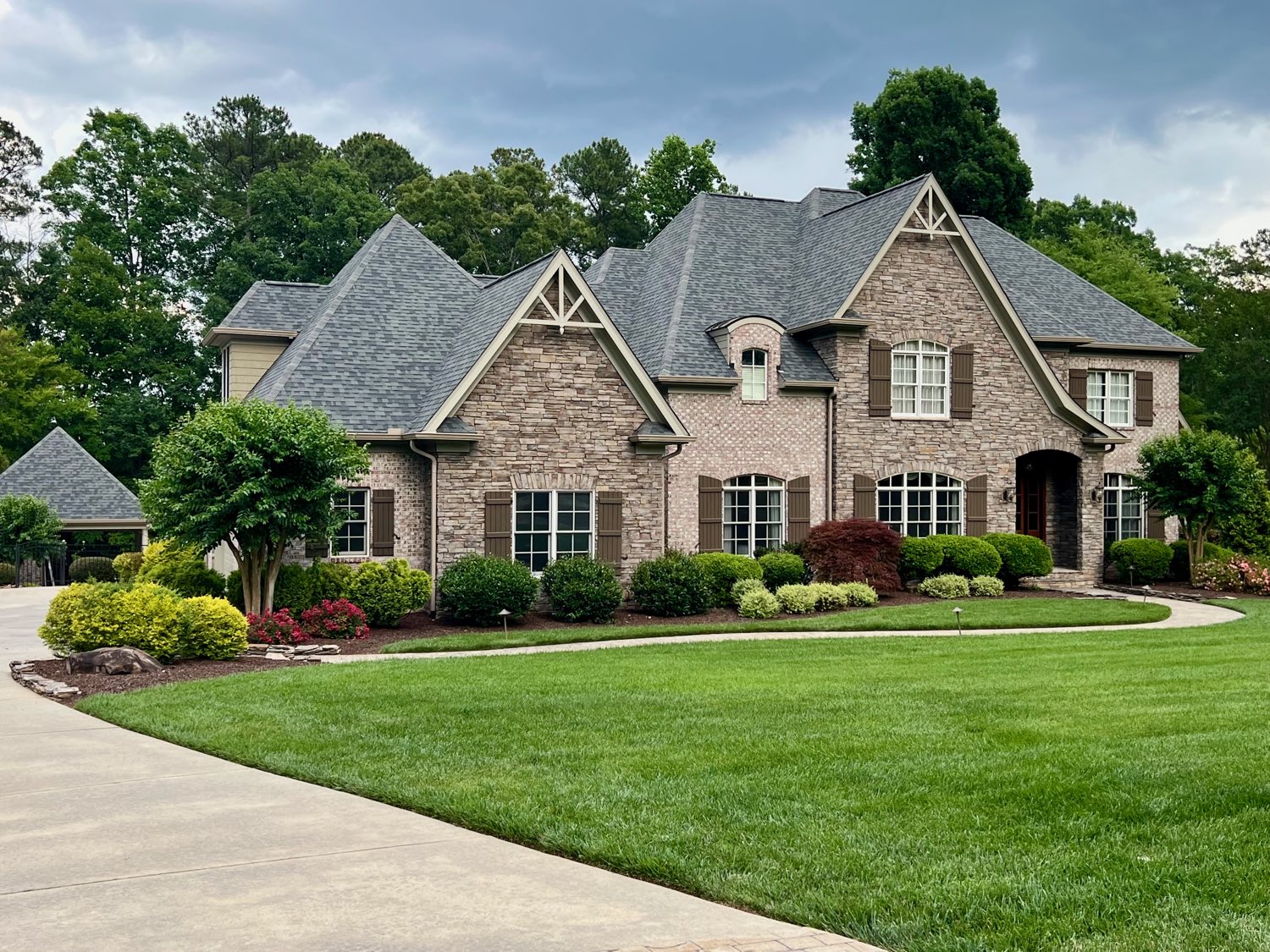 Brick and stone estate with mature landscaping